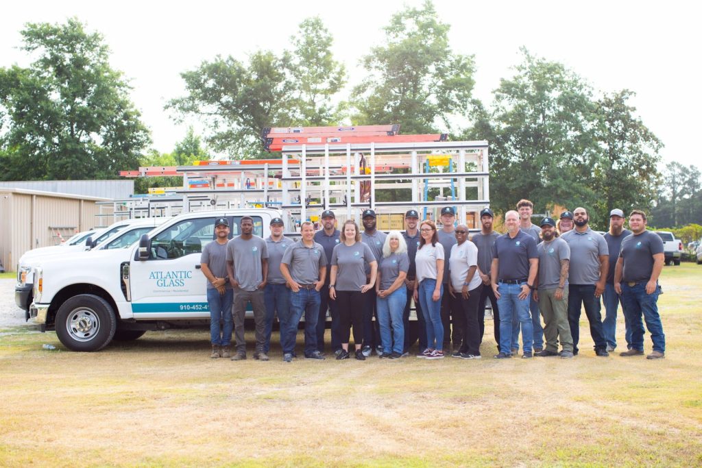 The Atlantic Glass team gathered in front of the company service trucks