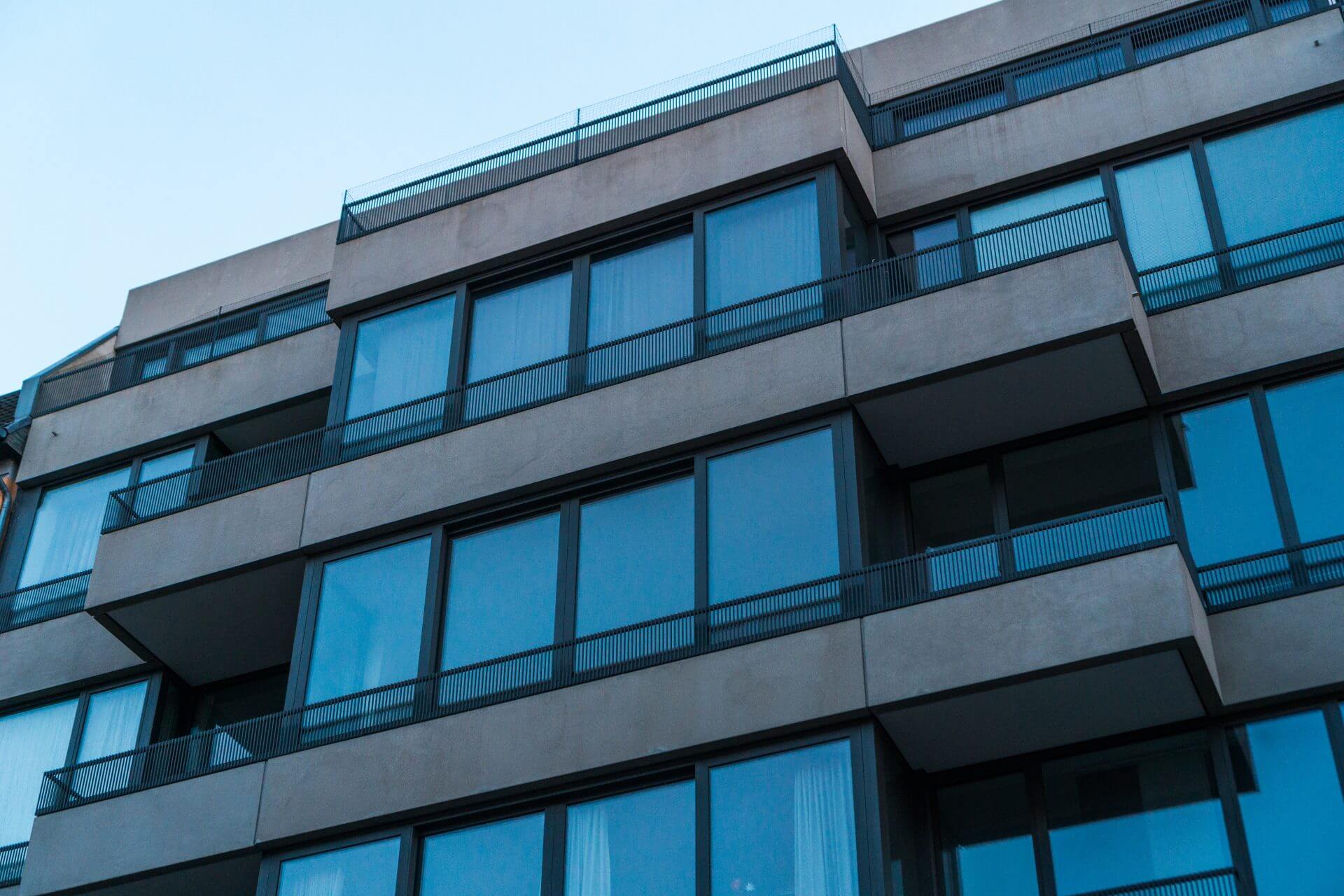 The glazed facade and balconies of a modern apartment building