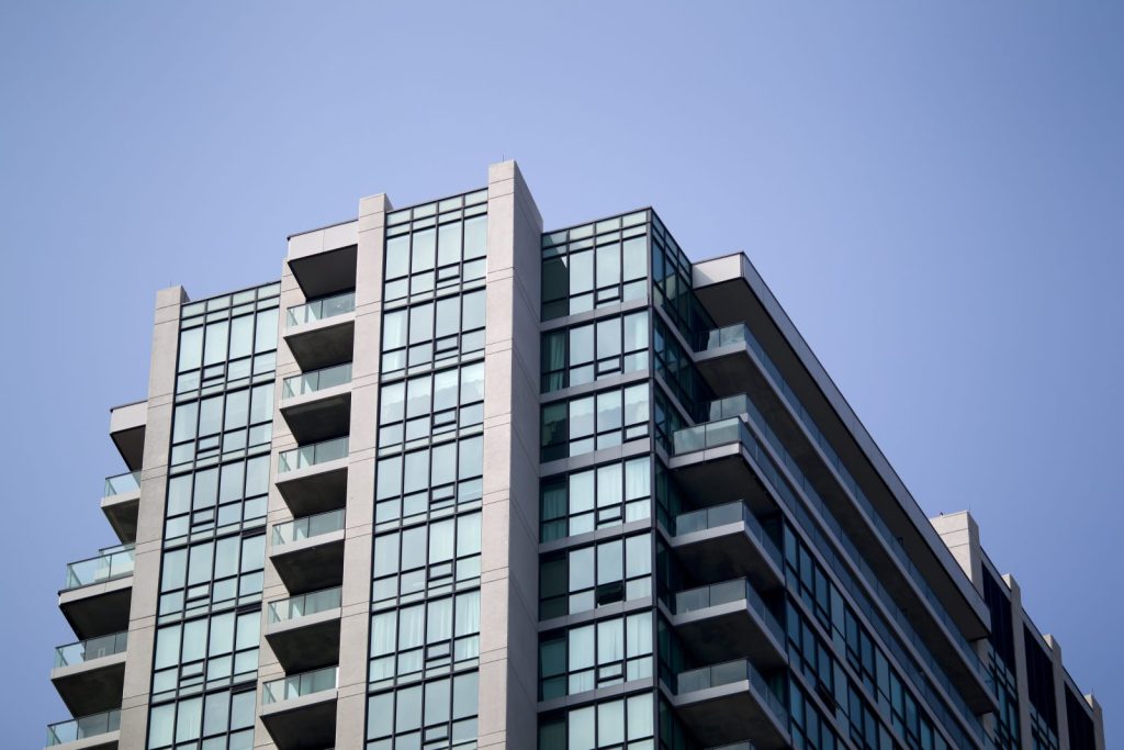 A concrete and glass apartment tower with recessed balconies