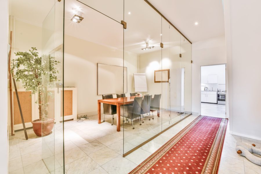 A frameless glass partition wall enclosing a meeting room