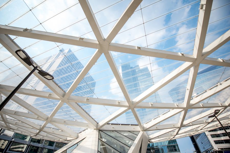 A glazed ceiling structure seen from below against the sky