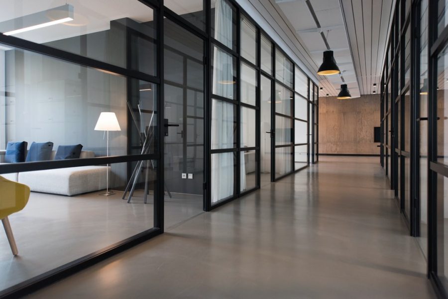 Office corridor lined with black-framed glass partitions
