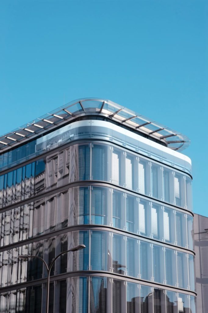 A curved commercial tower clad in a glass curtain wall