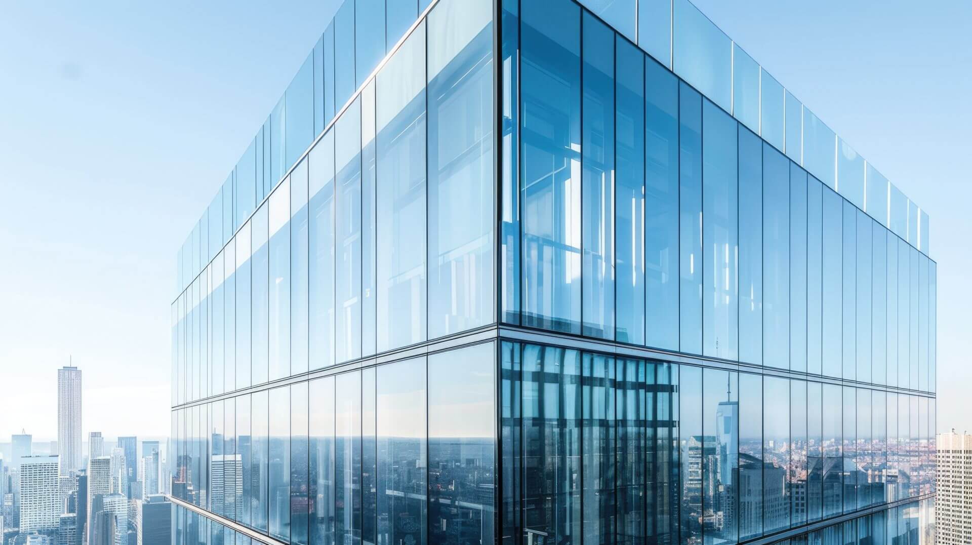 Corner of a glass-clad office tower above a city skyline