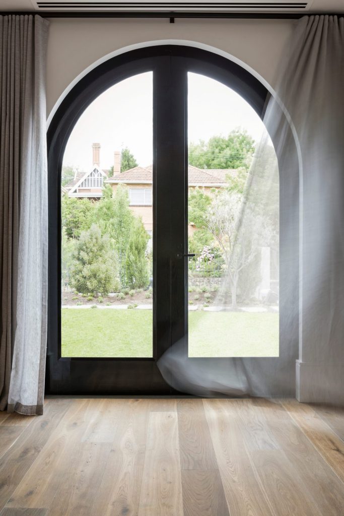 An arched glass door and window unit seen from inside a room