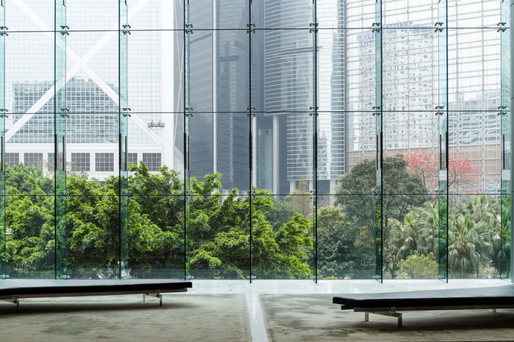 Full-height glass panels looking out onto trees and towers