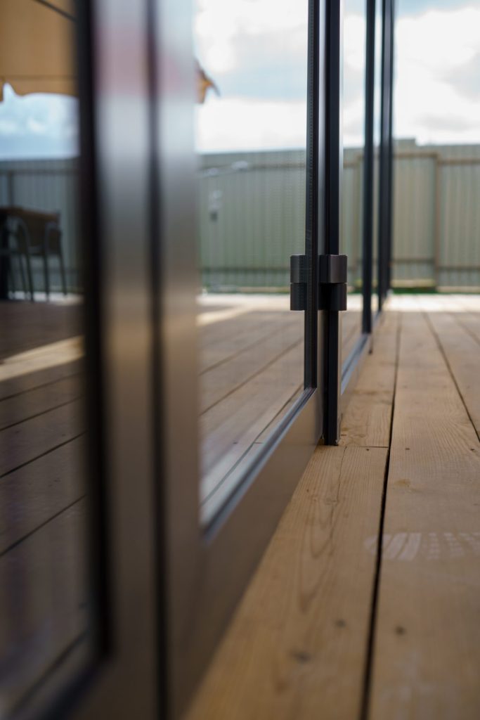 A dark-framed sliding glass door seen close up from outside