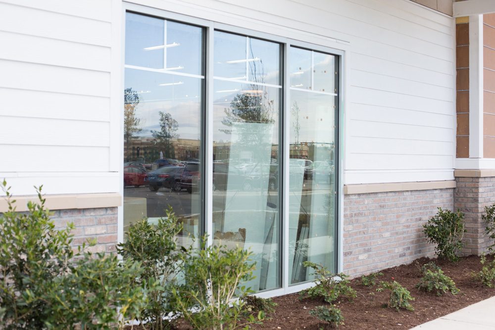 Tall storefront glazing on a white commercial building