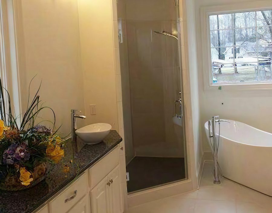 Bathroom with a frameless glass shower screen beside a freestanding bath