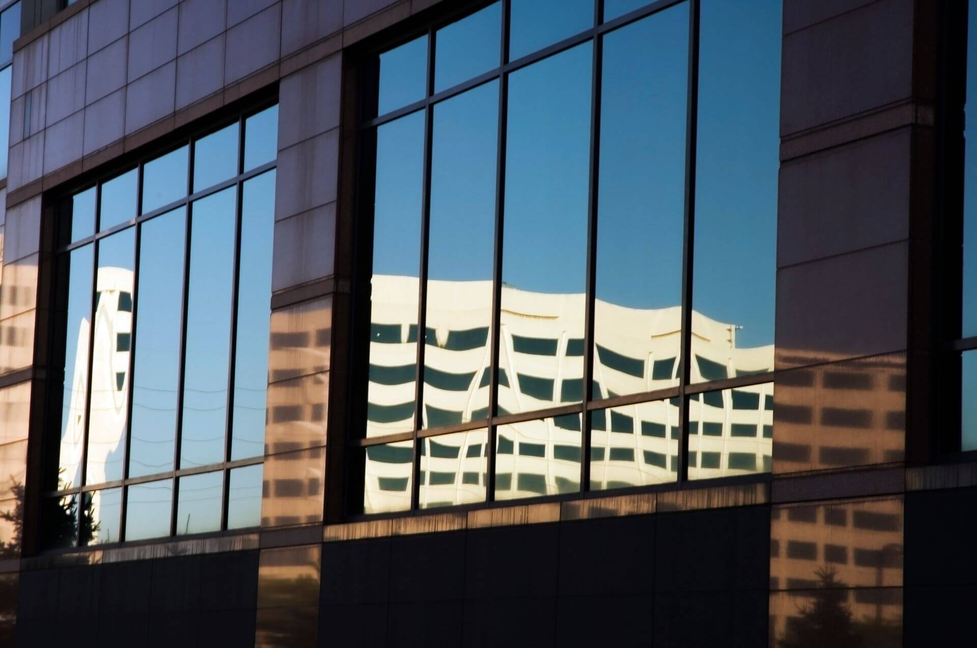 Sunlit glass facade of a commercial building